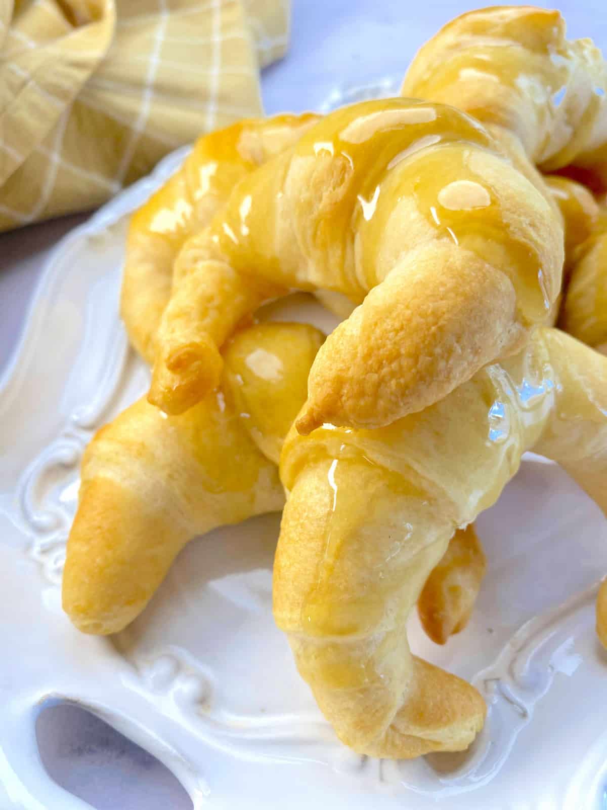 White platter filled with glazed croissants.