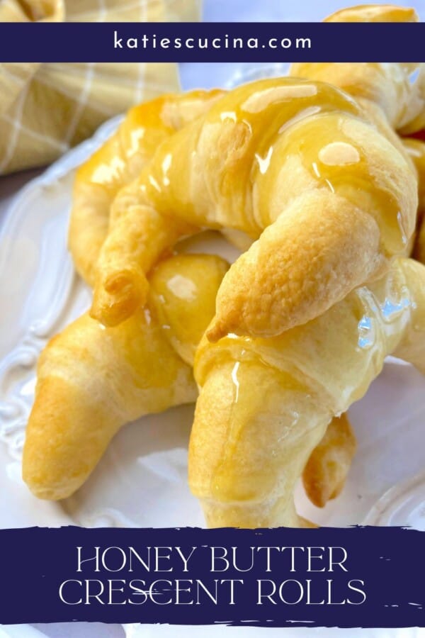 Baked glazed crescent rolls on a white baking tray with recipe title text on image for Pinterest.