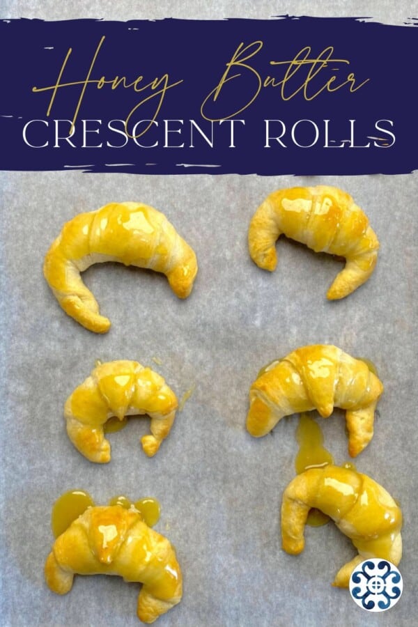 Parchment lined baking sheet with baked croissants with recipe title text on image for Pinterest.