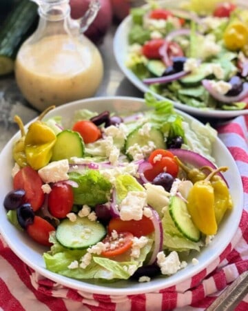 White bowls with salad with vegetables and feta in it.