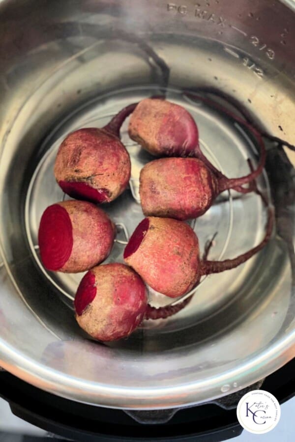 Raw beets in an instant pot with logo on right corner.