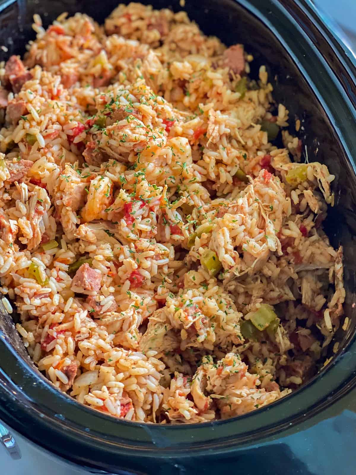 Black oval dish filled with rice, peppers, and chicken.