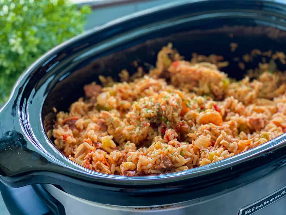 Oval slow cooker with rice, chicken, and shrimp in it.