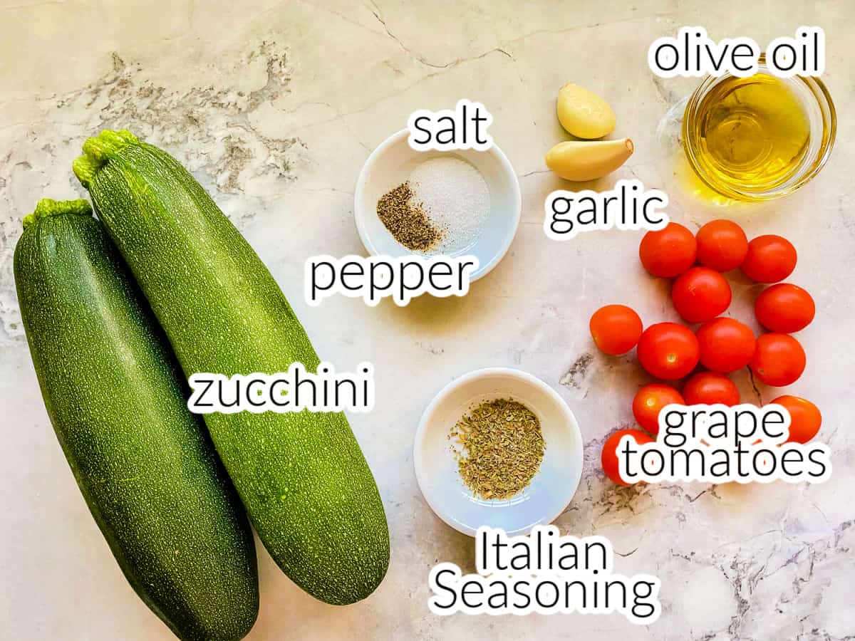 Ingredients for sautéed zucchini and tomatoes including seasonings, garlic, and oil.