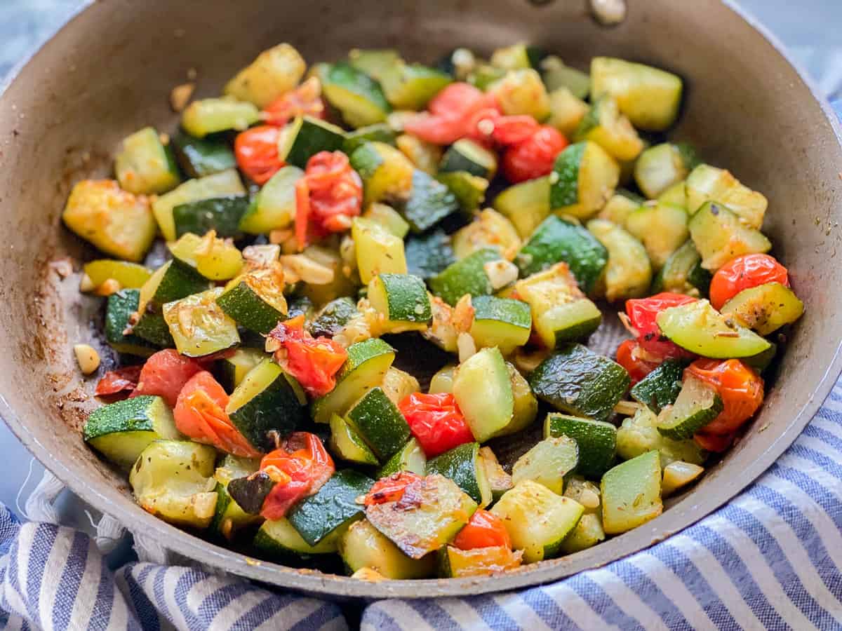 Pan of sautéed zucchini and tomatoes.