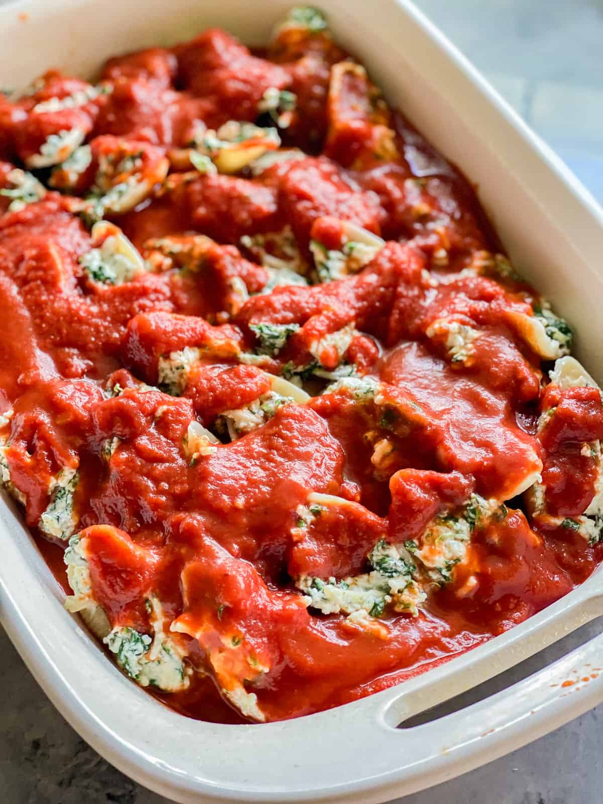 Up close photo of the Spinach Stuffed Shells covered in marinara sauce.