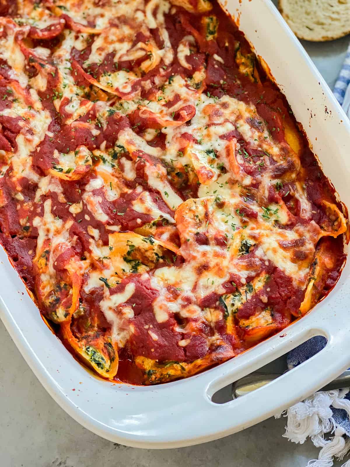 Baked Stuffed Spinach shells laying in a white baking dish.