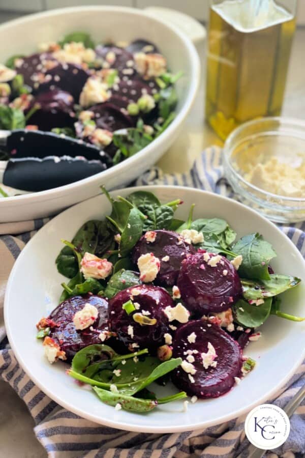 White bowl filled with feta and beets with logo on bottom right corner.