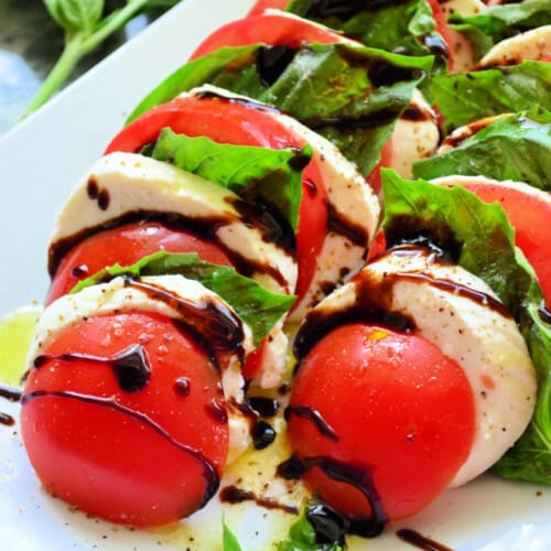 Slices of tomato, mozzarella and basil with balsamic drizzled on top.