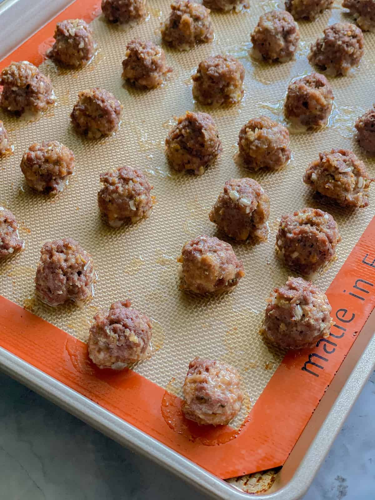Cooked meatballs on baking sheet.
