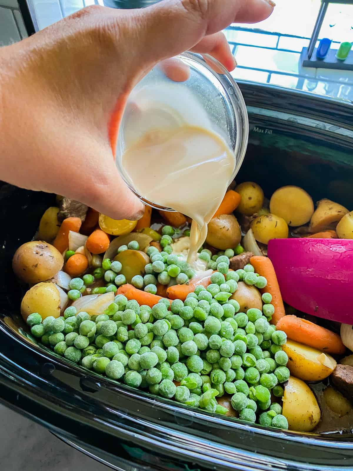 Slow cooker beef stew ingredients being added into the Instant Pot