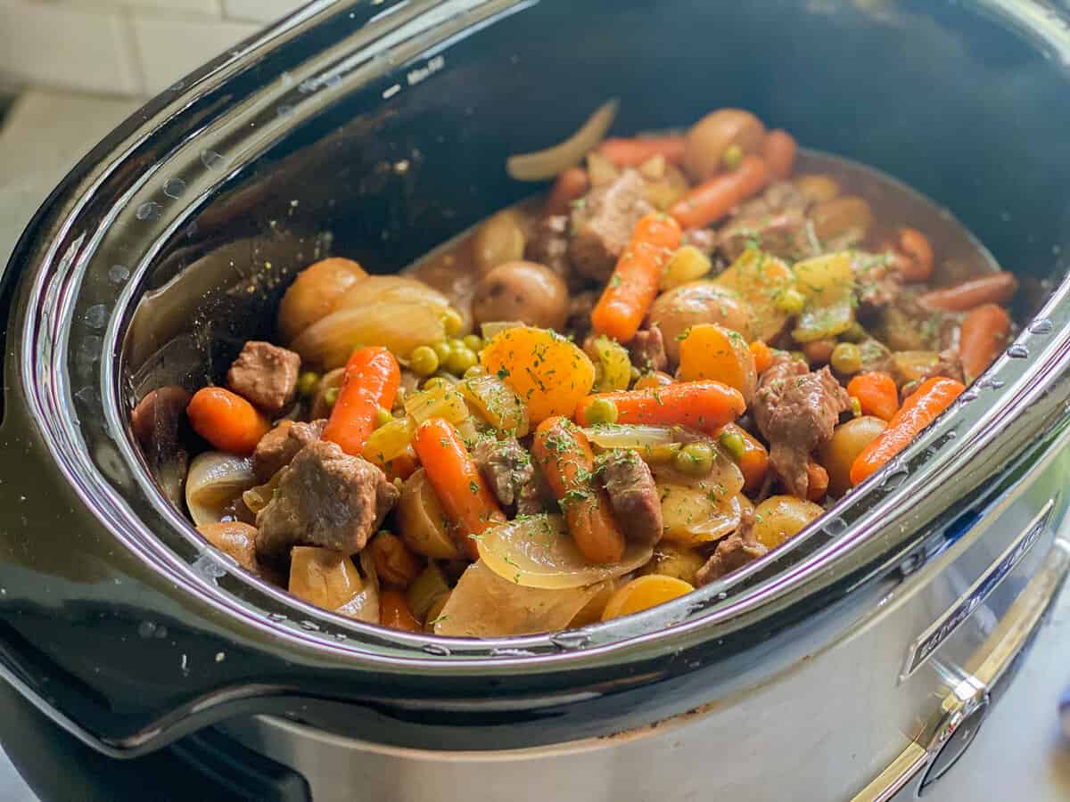 Angled view of the beef stew cooking in the slow cooker.