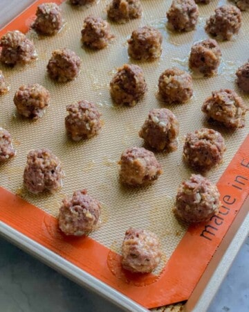 Cooked meatballs on baking sheet.