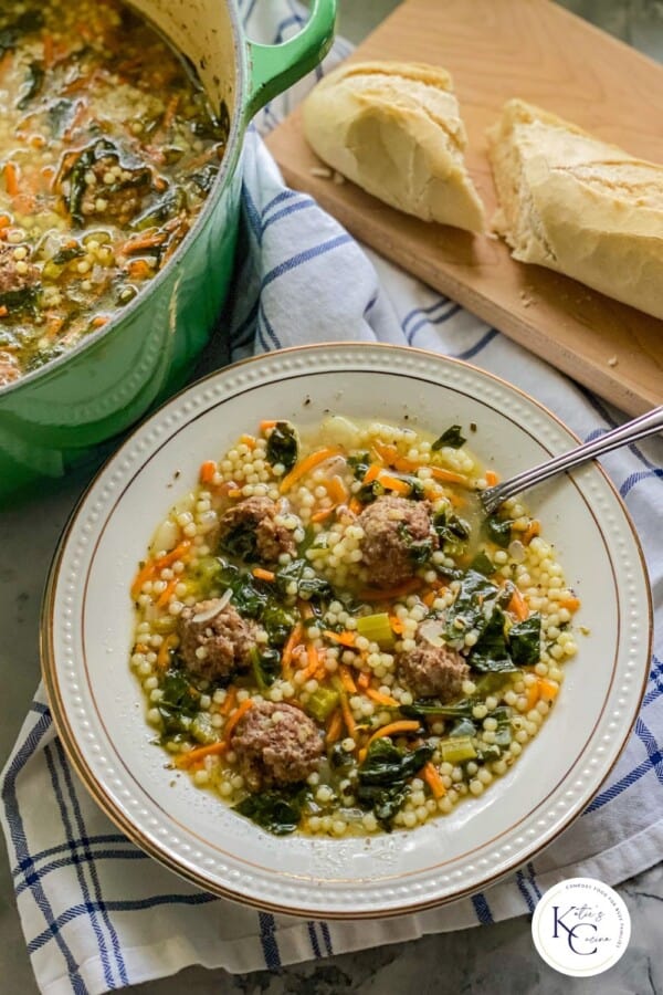 White bowl filled with italian meatball soup with logo on the right corner.