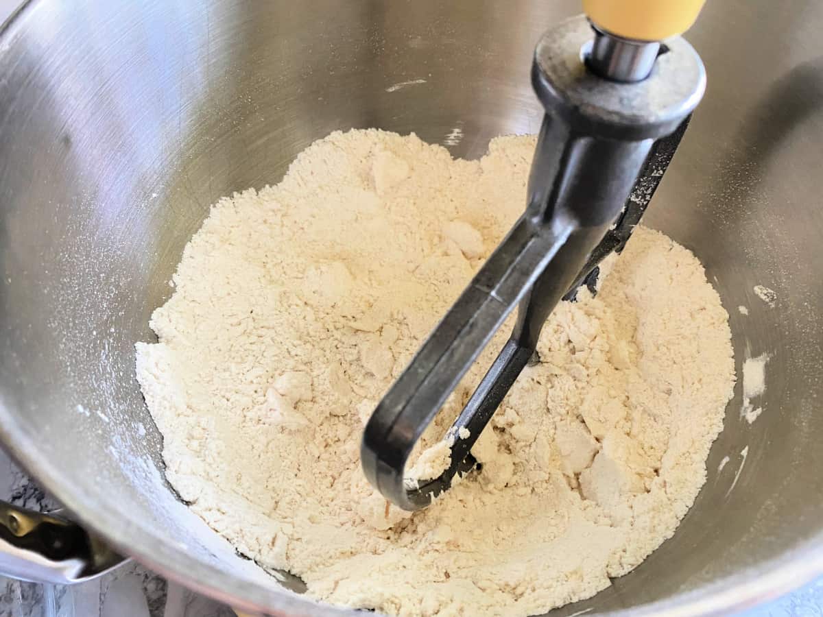 Stainless steel with flour and paddle attachment in bowl.