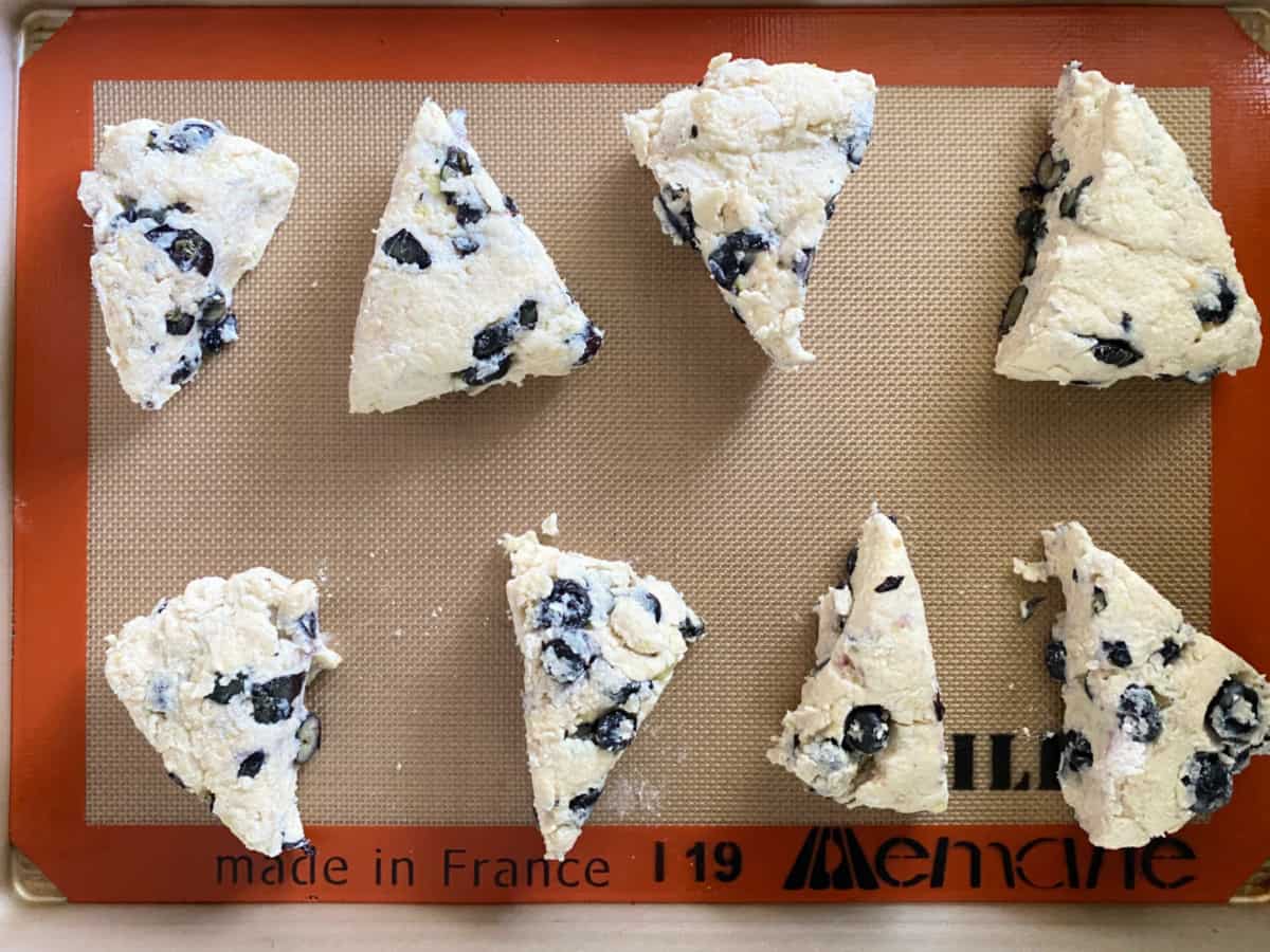 8 triangle scone dough wedges on a baking tray.