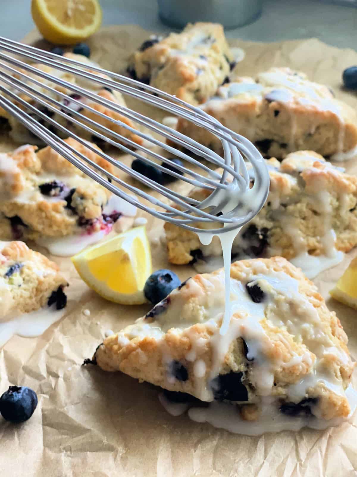 Whisk drizzling glaze on top of blueberry scones.