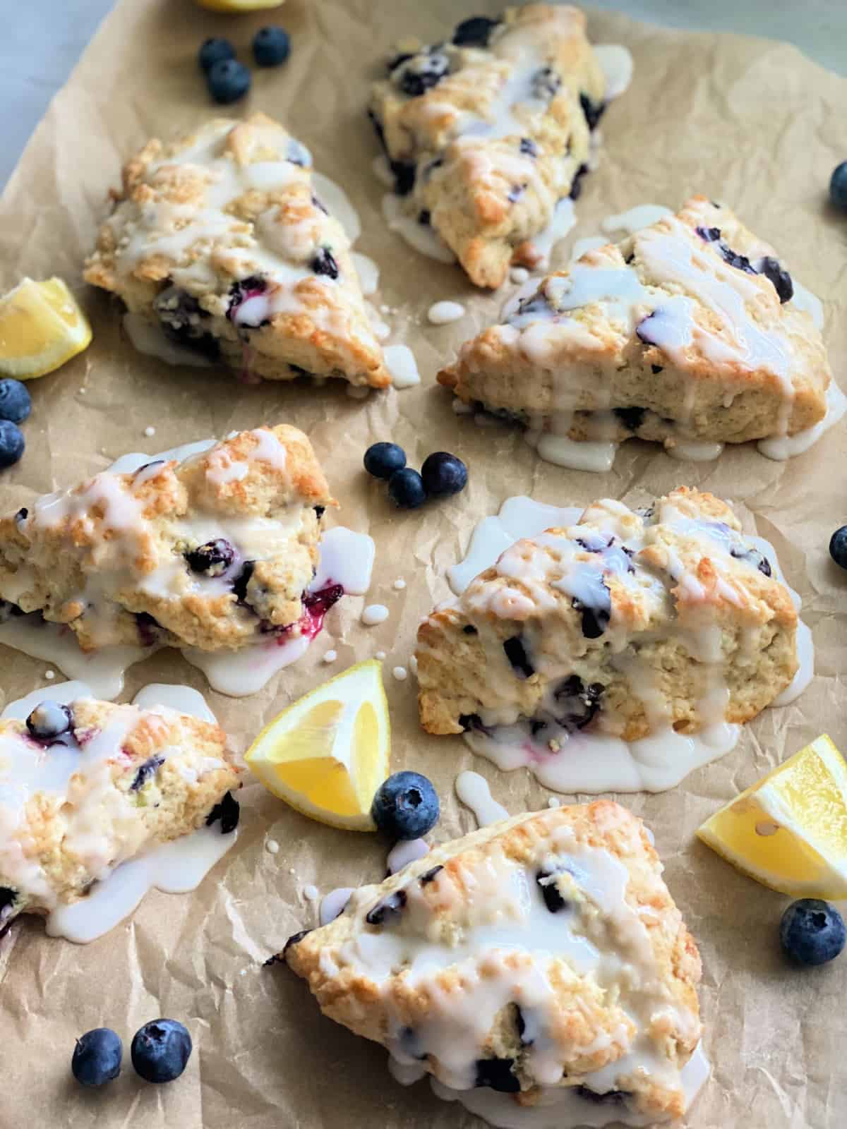 7 cooked scones with glaze and lemon wedges.