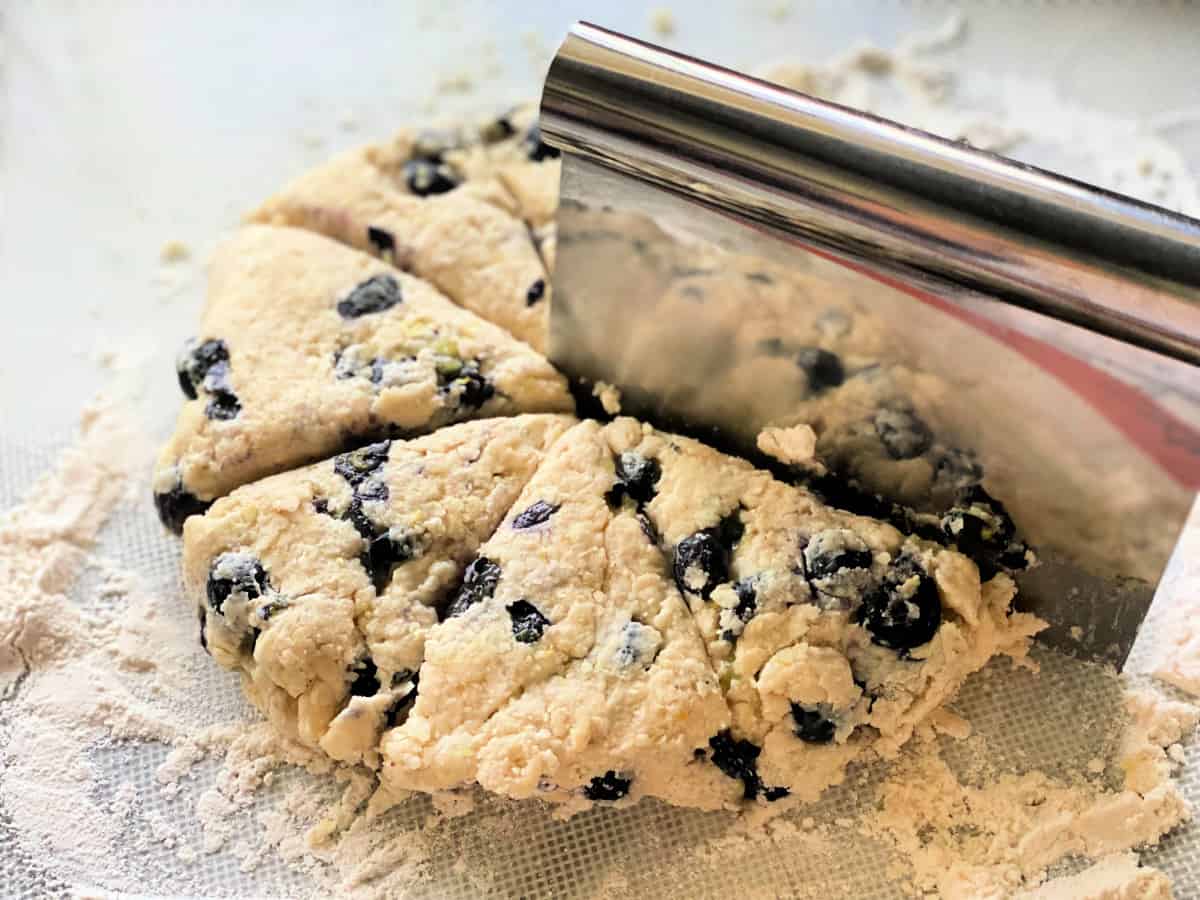 Round dough cut into 8 wedges with a bench knife on top.