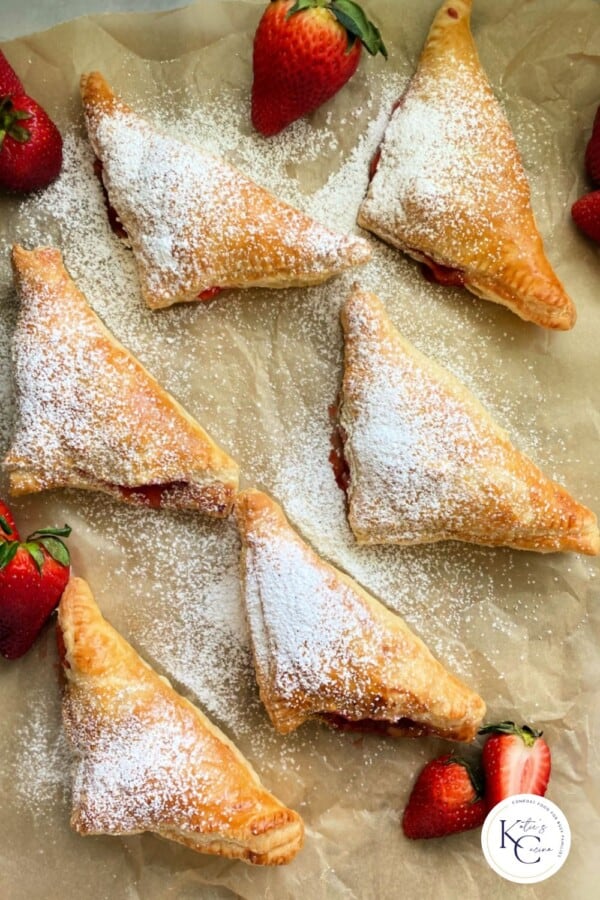 6 puff pastry turnovers on brown paper with logo on right corner.