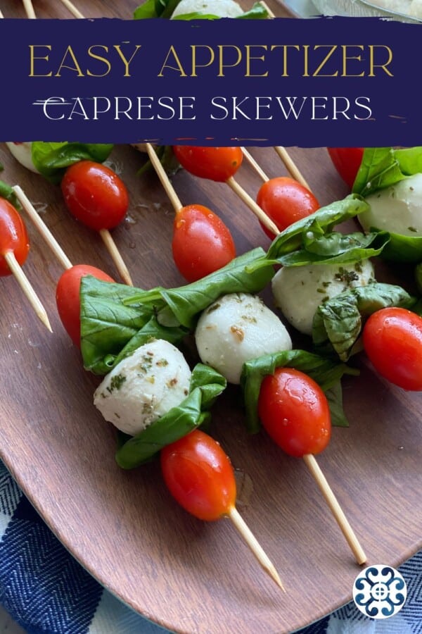 Brown tray with tomato, basil, and mozzarella skewers with recipe title text on image for Pinterest.