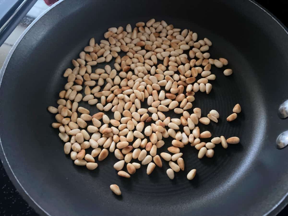 Black pan with toasted pine nuts.