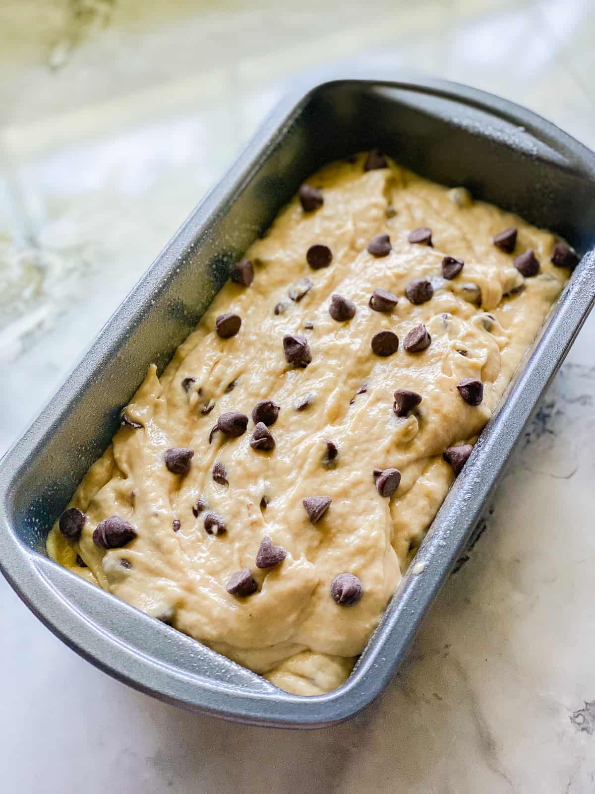 Metal pan filled with batter and chocolate chips.