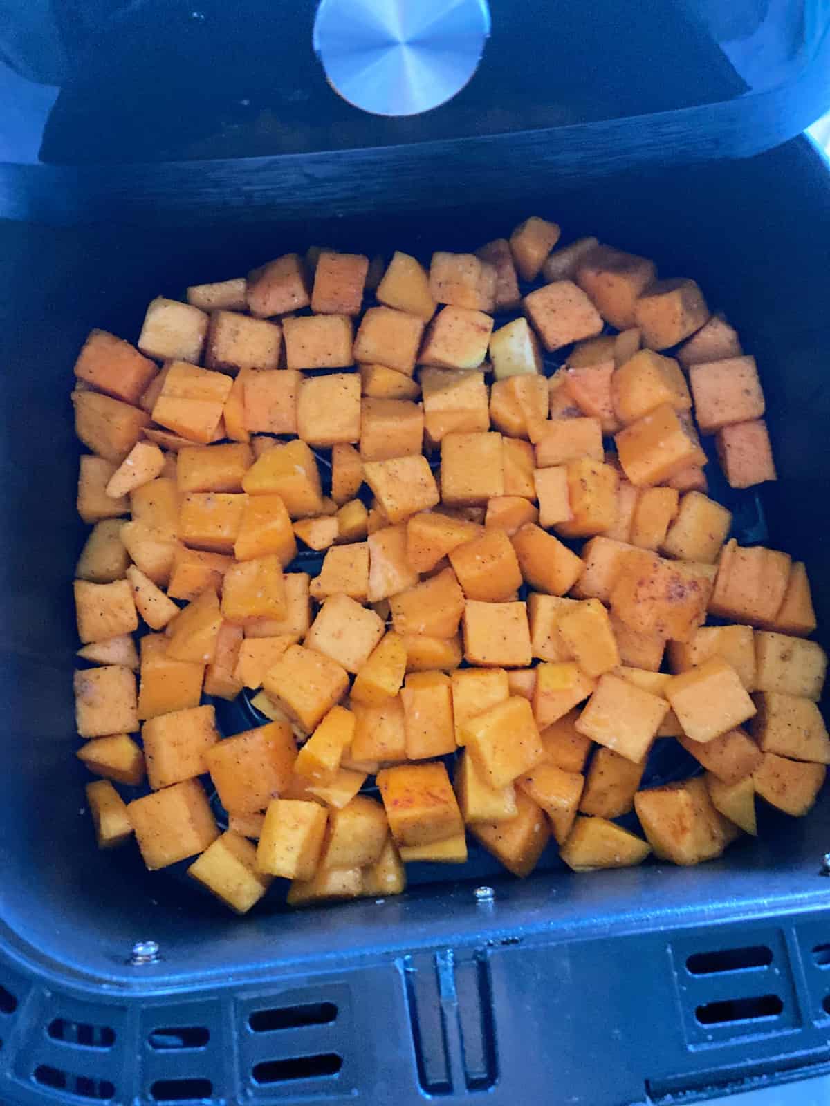 Raw butternut squash in an air fryer.