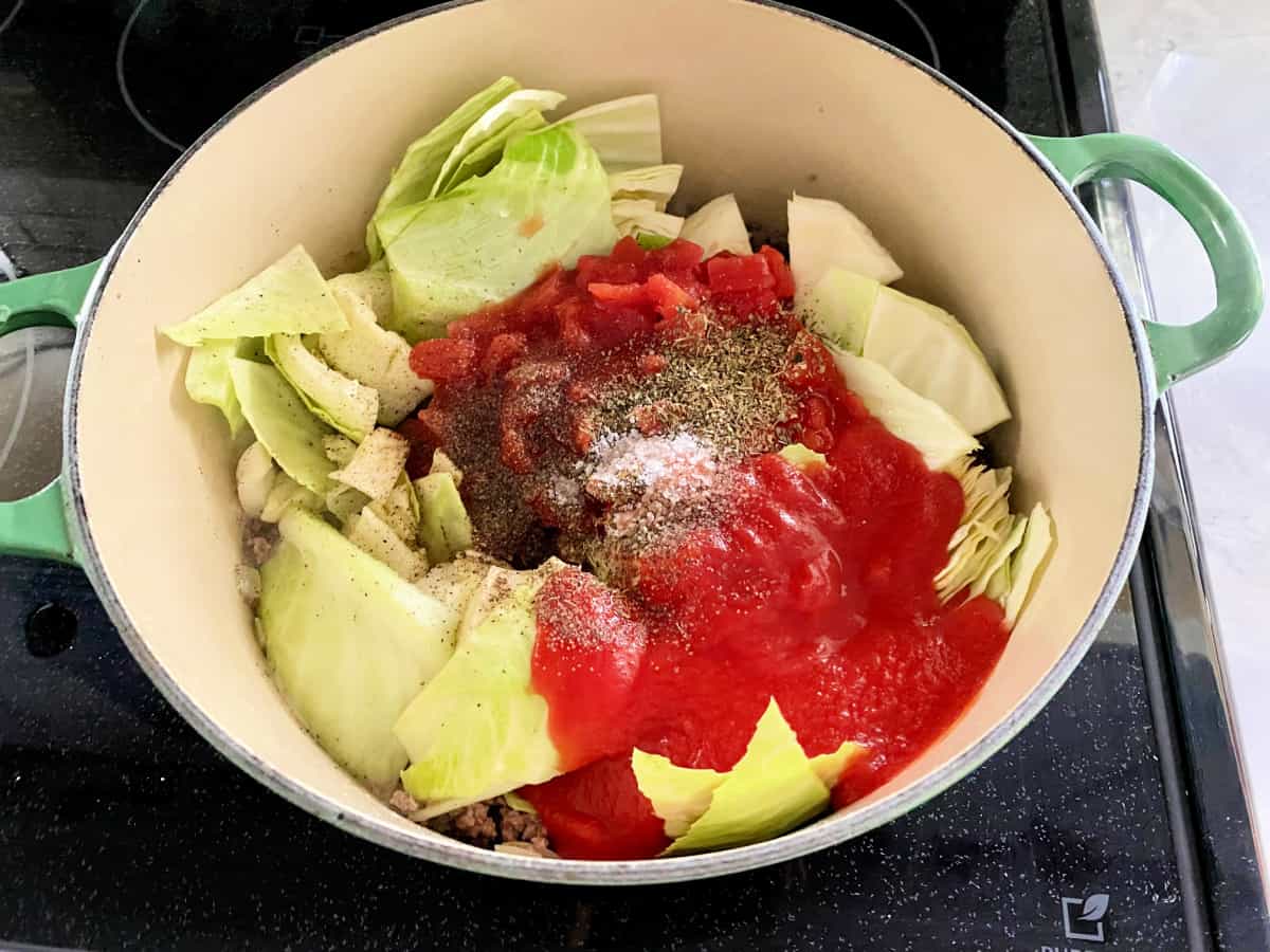 green pot on the stove filled with ingredients for stuffed cabbage soup
