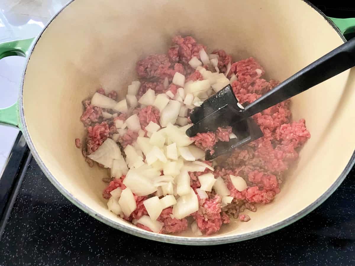 Pot on the stove filled with ingredients for stuffed cabbage soup