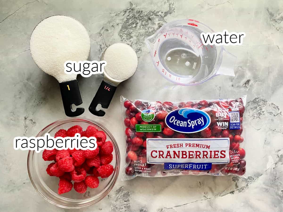 Ingredients on marble counter: raspberries, sugar, water, cranberries