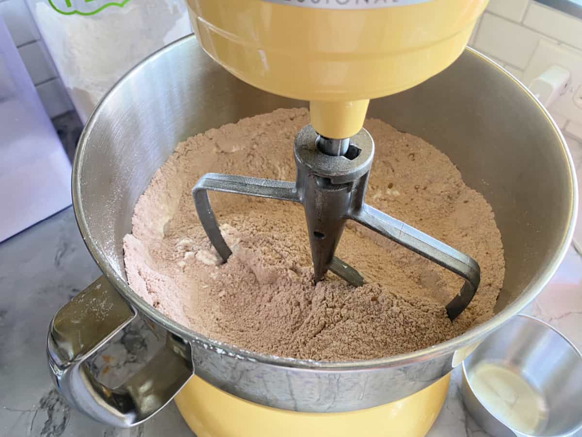 Chocolate cake powder ingredients inside KitchenAid mixing bowl.