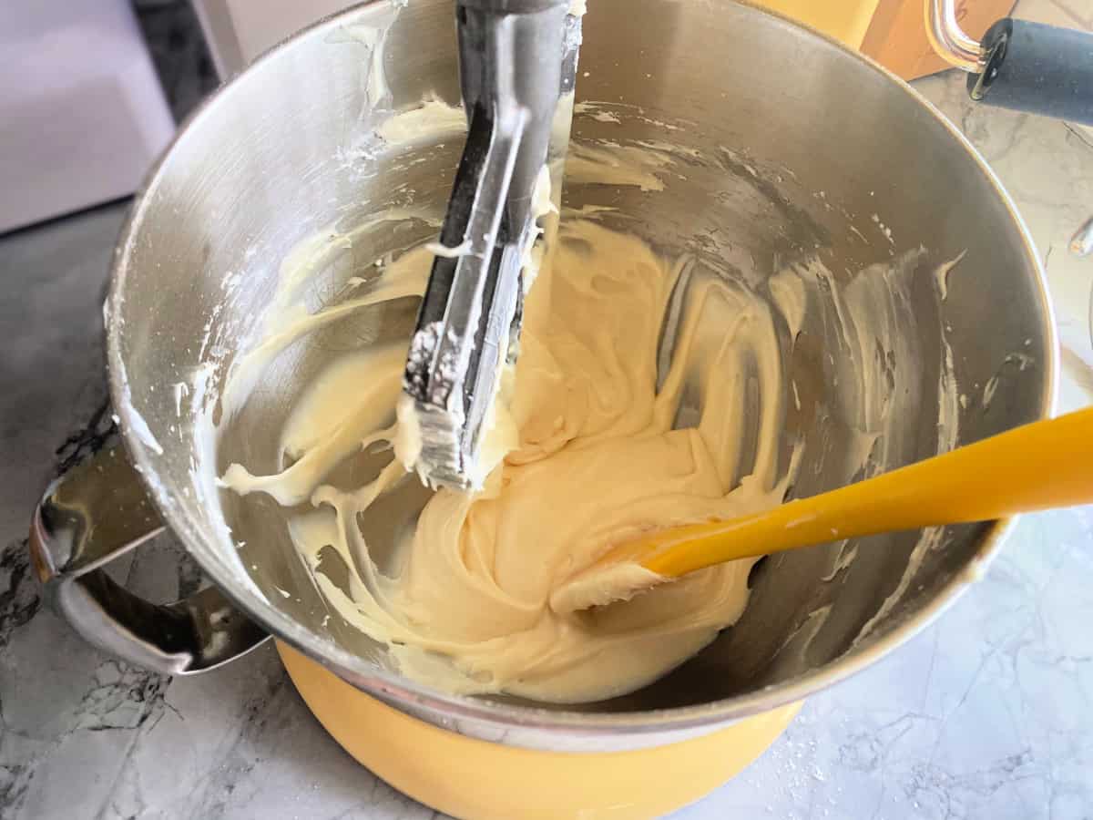 Cream cheese frosting being mixed inside mixer.
