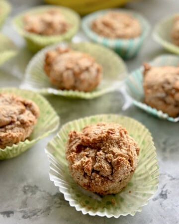 muffins on a marble countertop sitting on top of their wrappers.