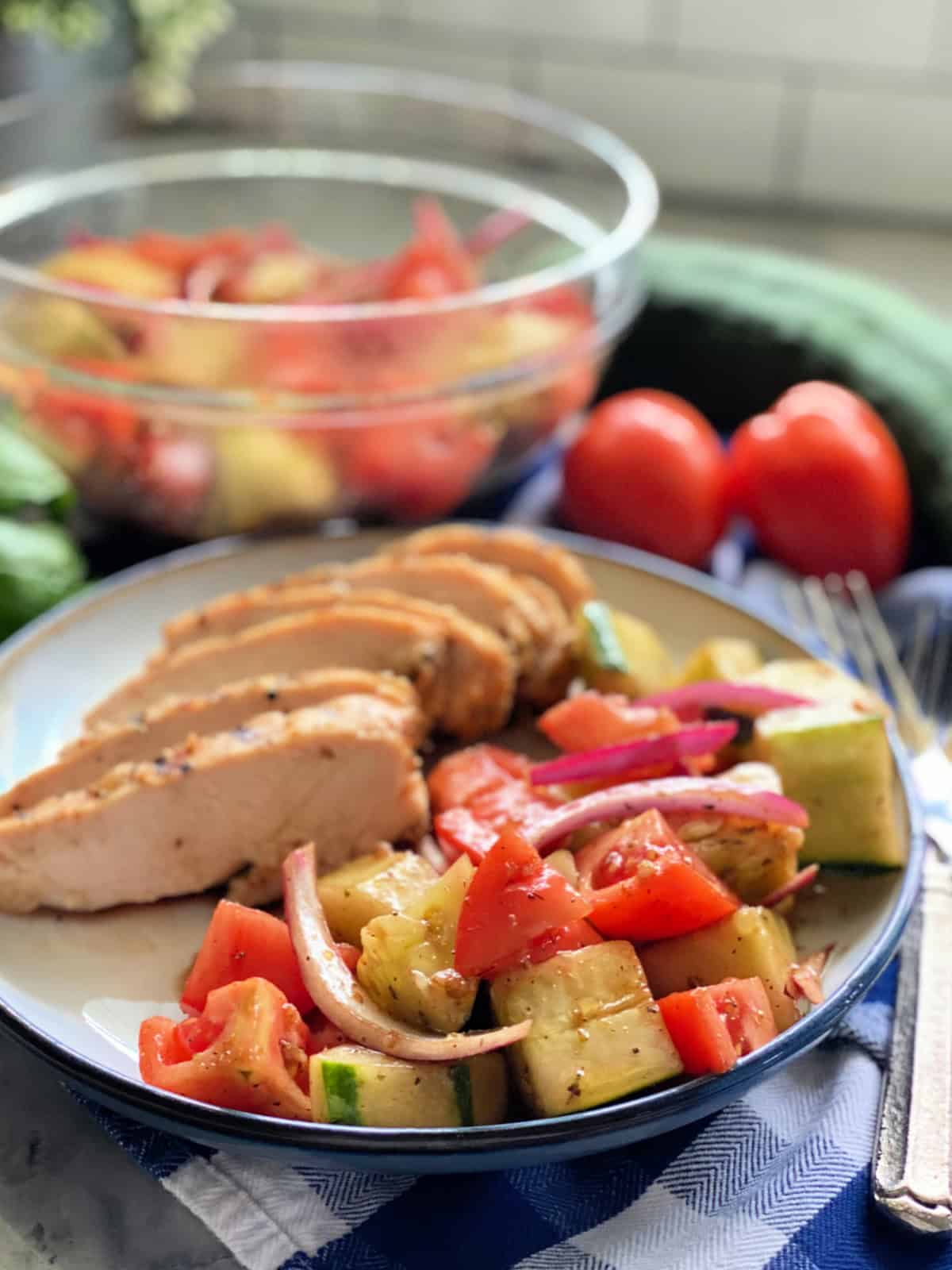 Plate with veggie salad and grilled chicken.