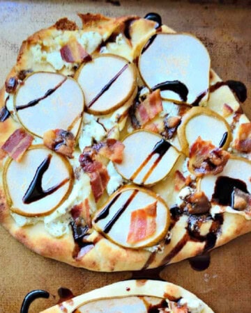 Square picture of a flatbread with bacon, sliced pears, and balsamic dressing.