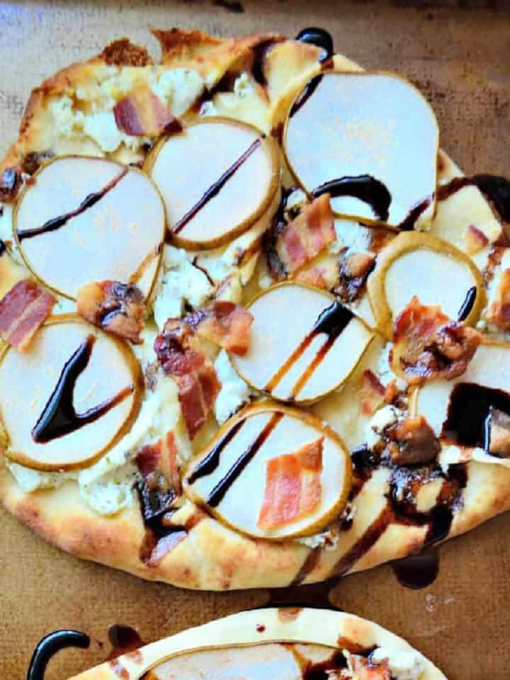 Square picture of a flatbread with bacon, sliced pears, and balsamic dressing.