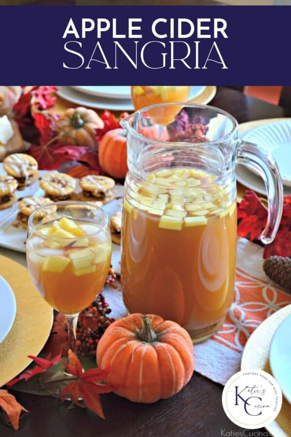 Glass pitcher filled with sangria and a wine glass on a table setting with text on image for Pinterest.