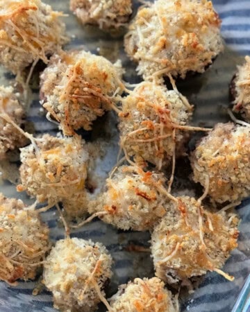 Glass dish filled with baked stuffed mushrooms.