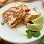 Quesadilla sliced in 4 on a white plate.