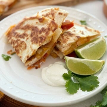 Quesadilla sliced in 4 on a white plate.