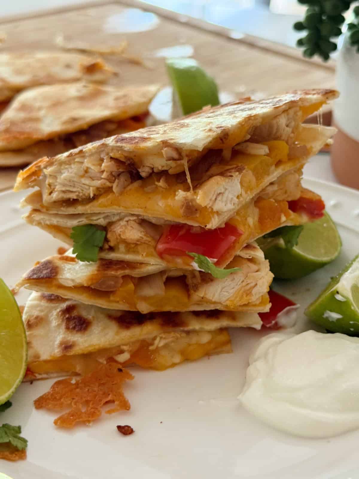 Stacked cut pieces of quesadilla on a white plate.