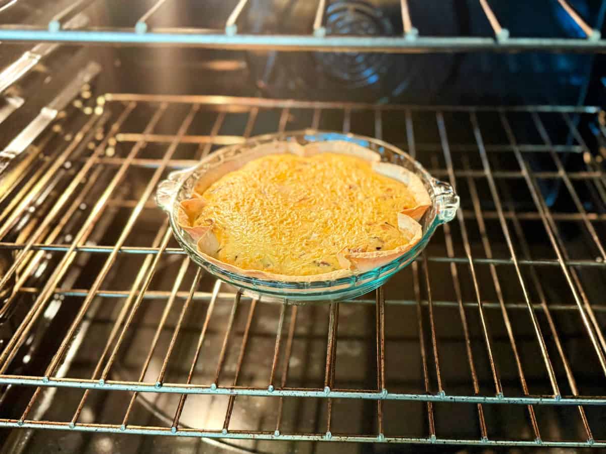 Glass baking dish filled with tortilla and egg in an oven.