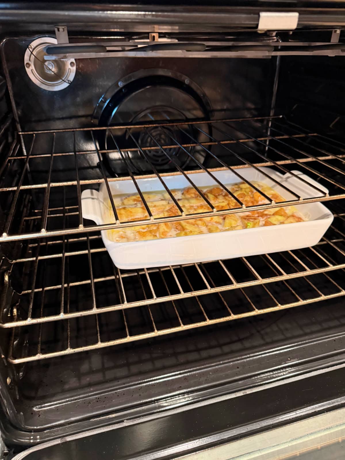 White baking dish filled with cobbler in an oven.