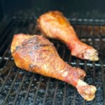 Two turkey legs on a black grill grate