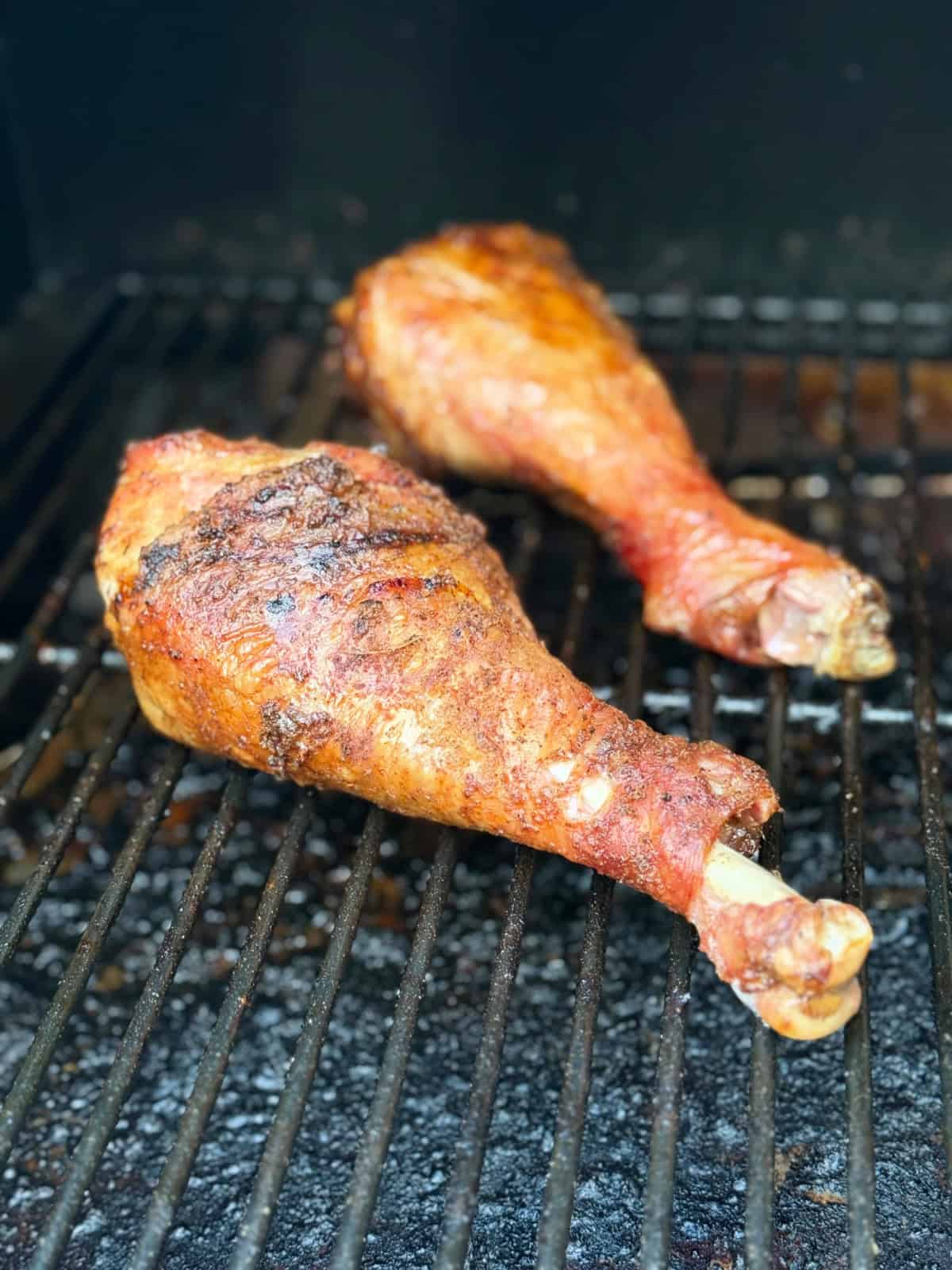 2 browned turkey legs on a grill.