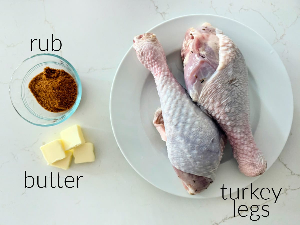 Ingredients on a counter; turkey legs, rub, and butter.