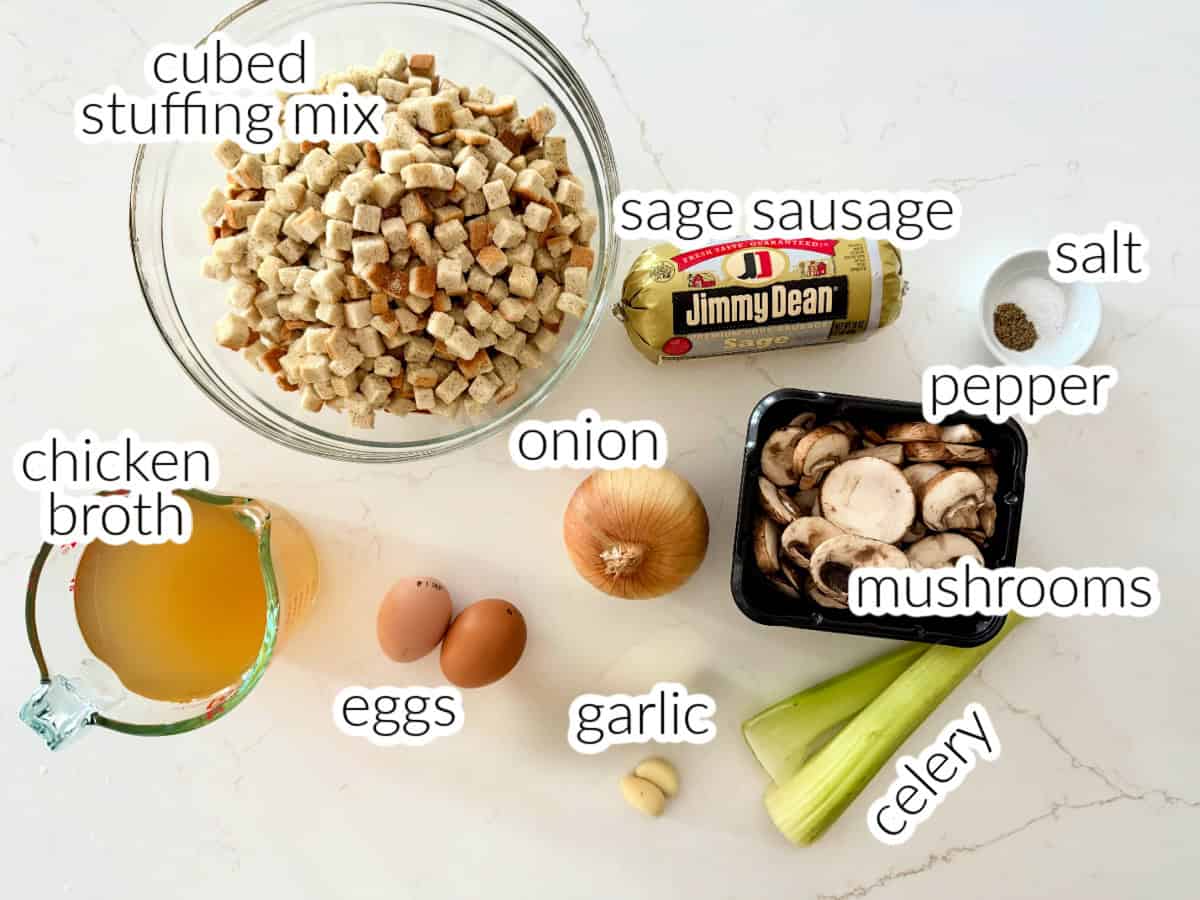Ingredients on counter; mushrooms, sausage, eggs, onion, garlic, celery, cubed stuffing mix, and chicken broth.