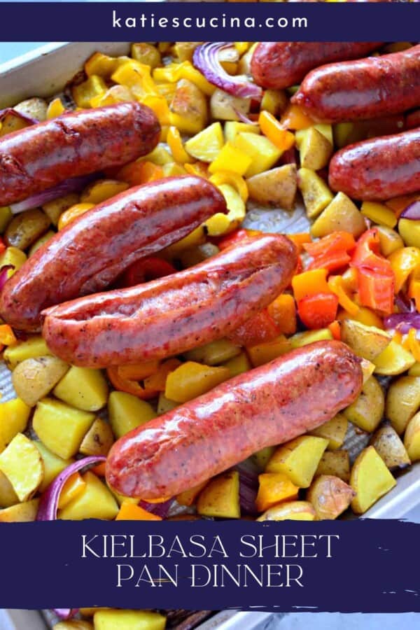 Silver baking sheet with diced potatoes, peppers, red onions, and sausage with text on image for Pinterest.